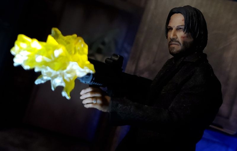 Action pose of the Mezco One:12 Collective John Wick figure demonstrating its articulation, highlighting the range of motion in the arms and legs.