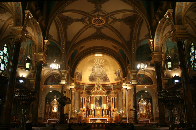 The ornate reredos behind the high altar in St. John Cantius Church, featuring Mannerist clustered columns and a skylight that illuminates the elaborate structure.