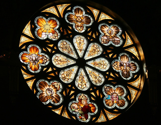 Stained glass window in St. John Cantius Church, illustrating the golden hues and detailed artistry that are characteristic of the church's interior.