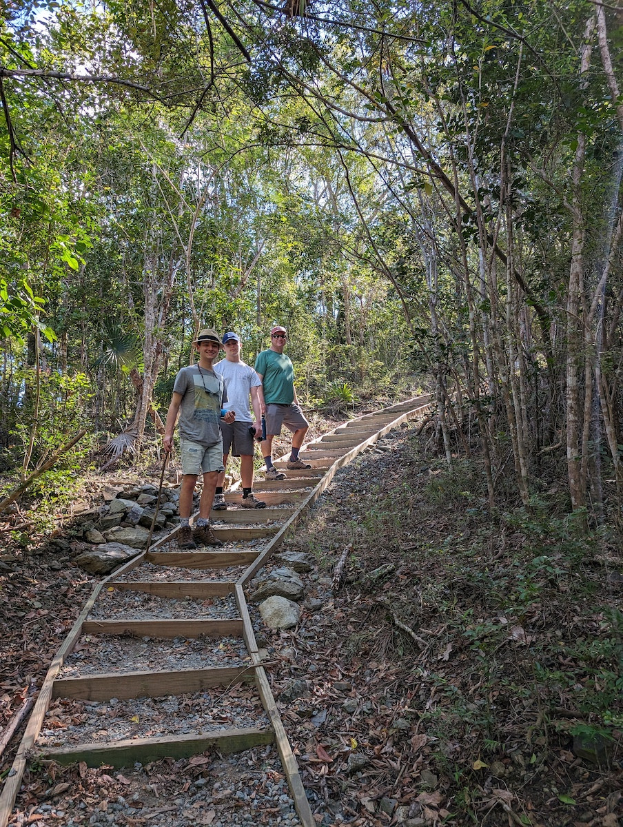 Family hiking up a steep staircase on Cinnamon Bay Trail, St. John
