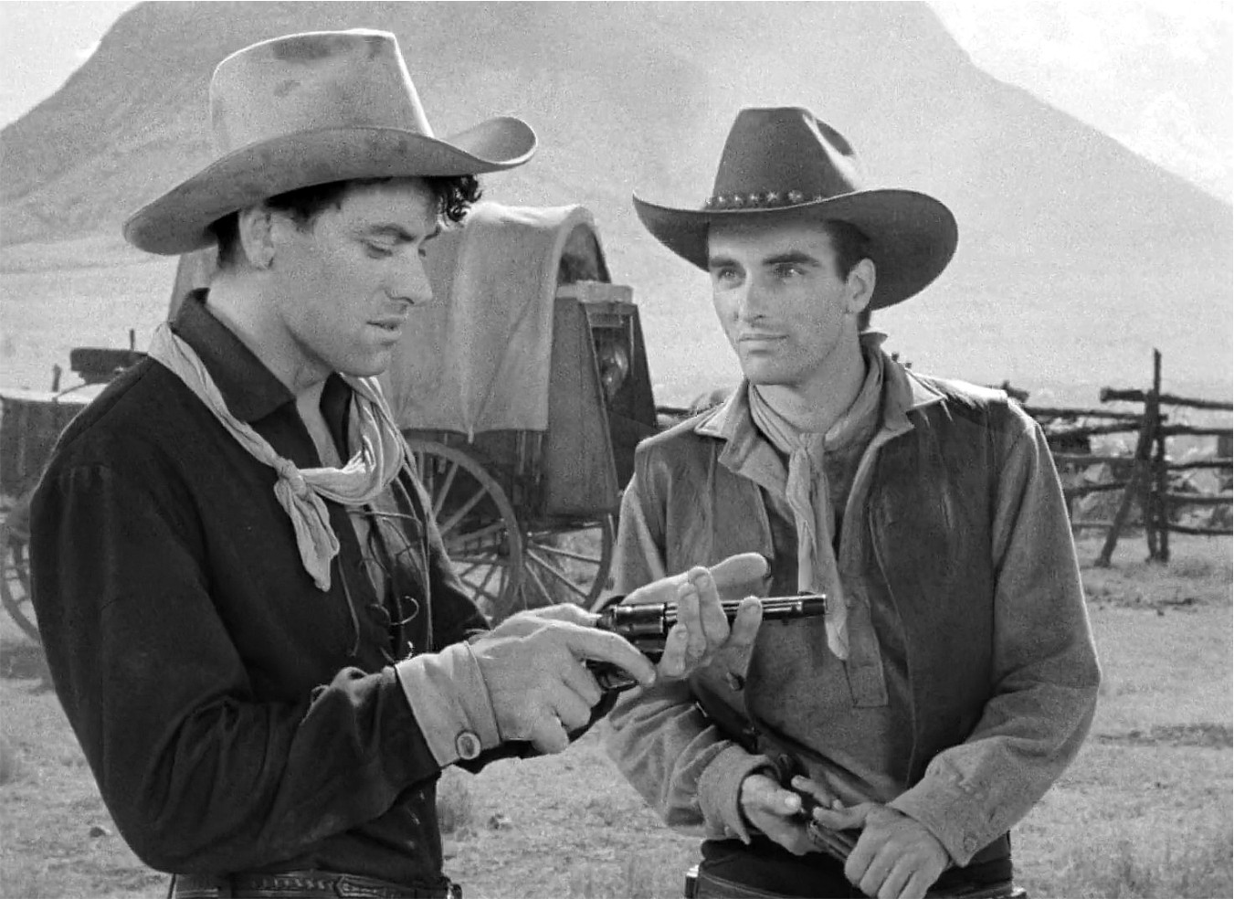 John Wayne and Montgomery Clift share a tense moment in Red River, highlighting their contrasting acting styles and the film's generational conflict