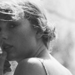 Taylor Swift in a confident pose, looking directly at the camera, alt=Taylor Swift embodies resilience and self-empowerment.